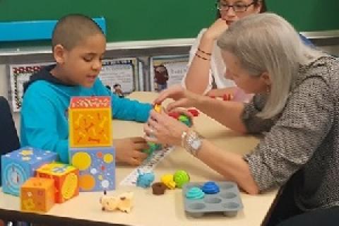 一个母亲与一个患有自闭症的孩子在护理技能培训研讨会。照片由Mom2Mom