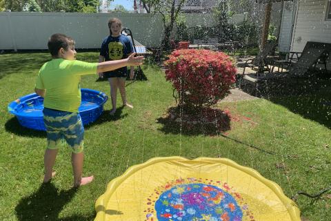 詹姆斯Guttman的孩子们在洒水中玩耍。