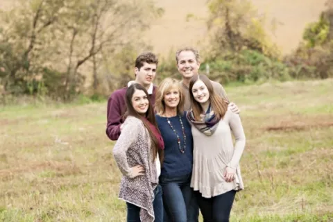 克丽丝蒂雅各布森和她的家人在牧场外摆姿势拍照